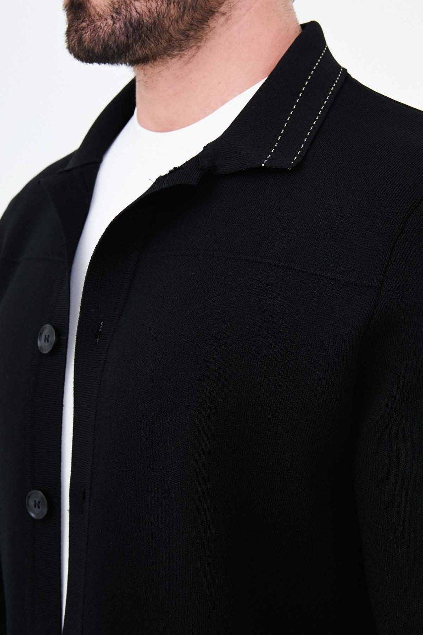 Close-up of the black cardigan showing knit texture and contrast stitching on the collar