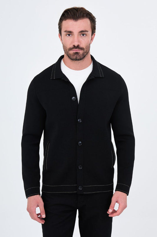 Man wearing a black button-front cardigan with contrast trim, front view