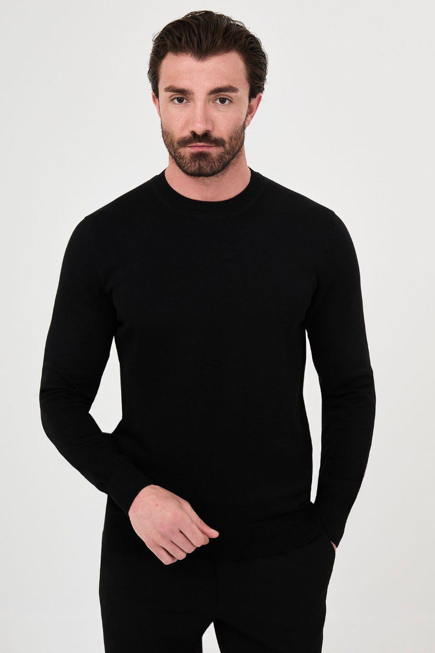 Front view of a man wearing a black crew neck sweater with long sleeves