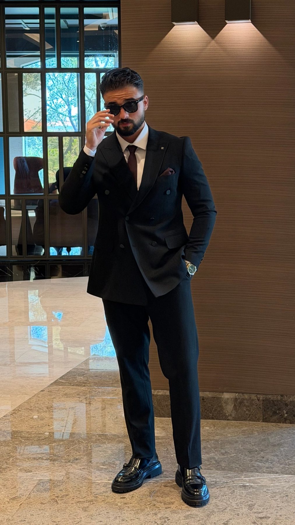 Men's black pinstripe double-breasted suit styled with shirt and tie