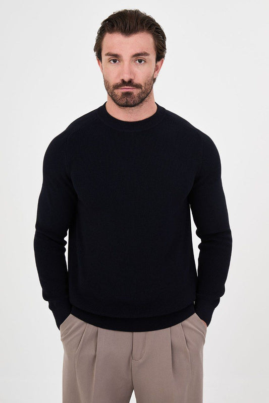 Front view of a man wearing a black ribbed raglan crew neck sweater