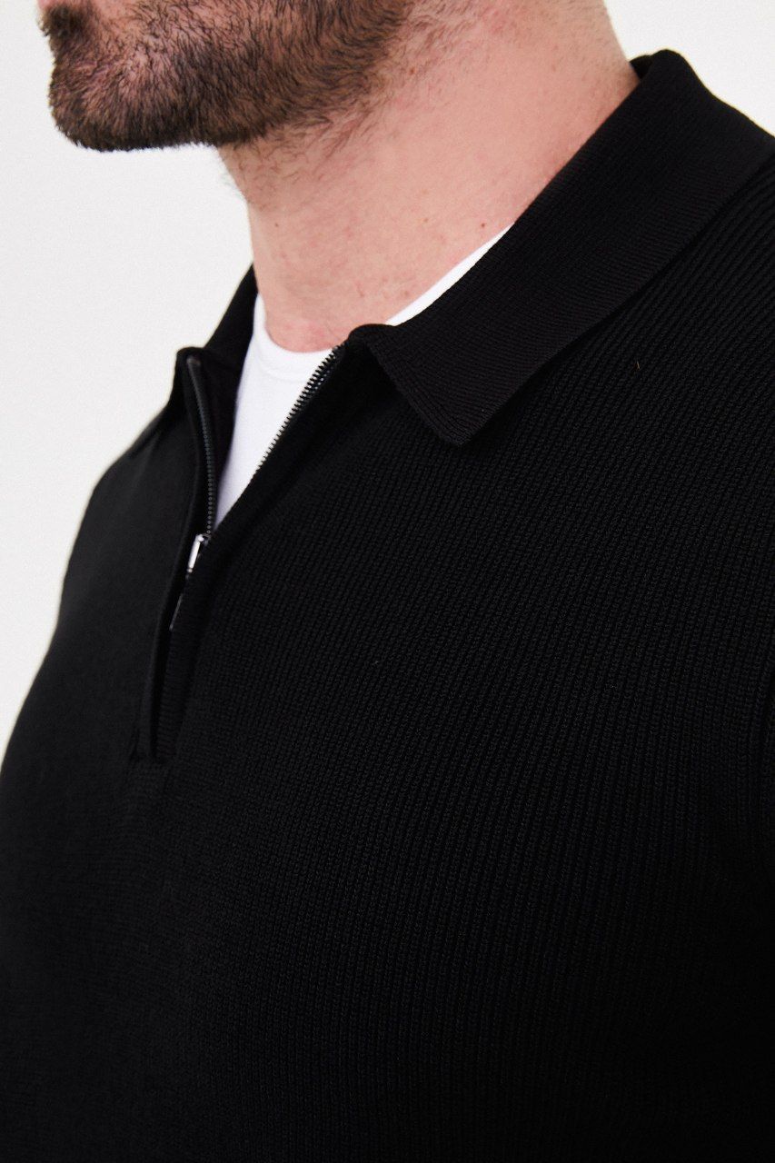 Close-up of the black sweater's ribbed knit, polo collar and short zip opening