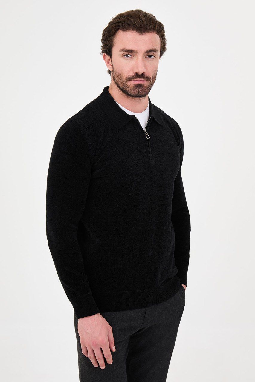 Angled view of a man wearing a black textured quarter-zip polo sweater