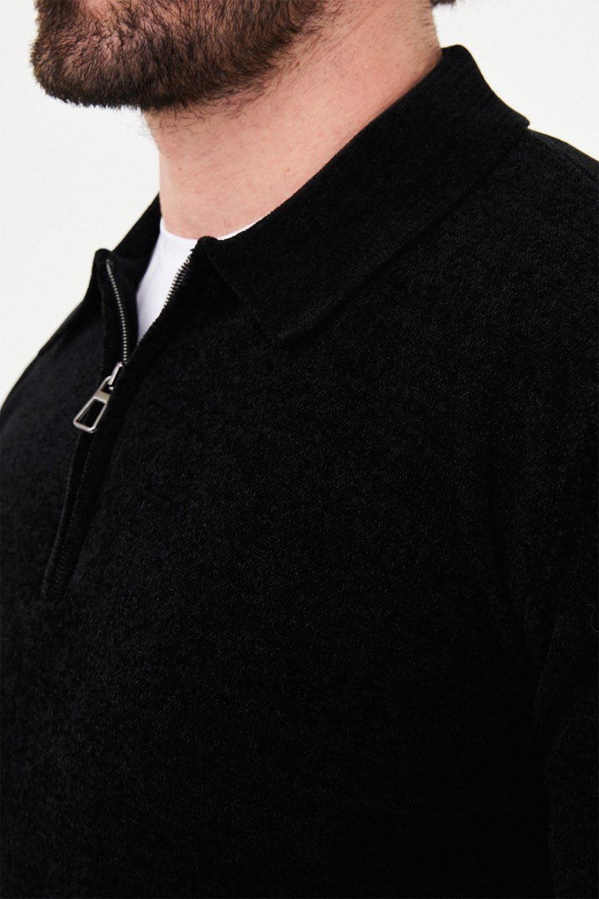 Close-up of the black sweater's textured knit, polo collar and metal quarter-zip fastening