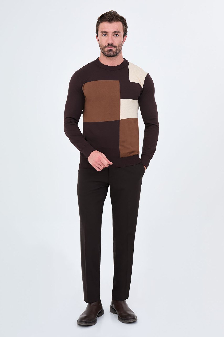 Man wearing a brown colour-block sweater with black trousers