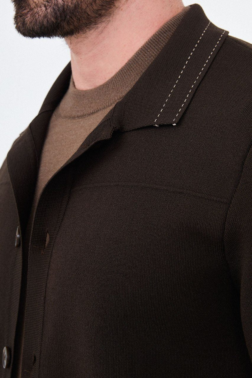 Close-up of the brown cardigan showing knit texture and contrast stitching on the collar