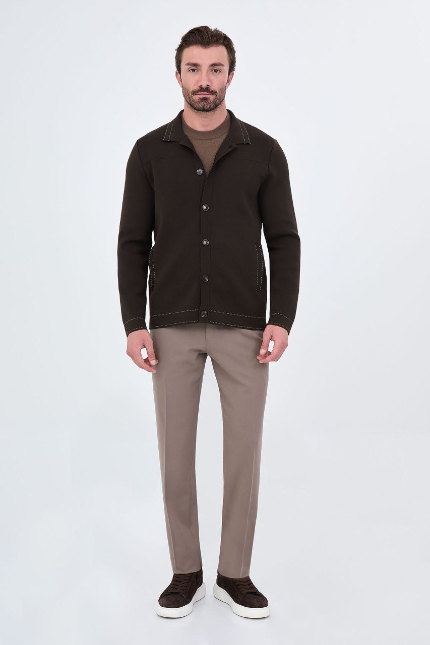 Man wearing a brown button-front cardigan with contrast trim, full outfit view
