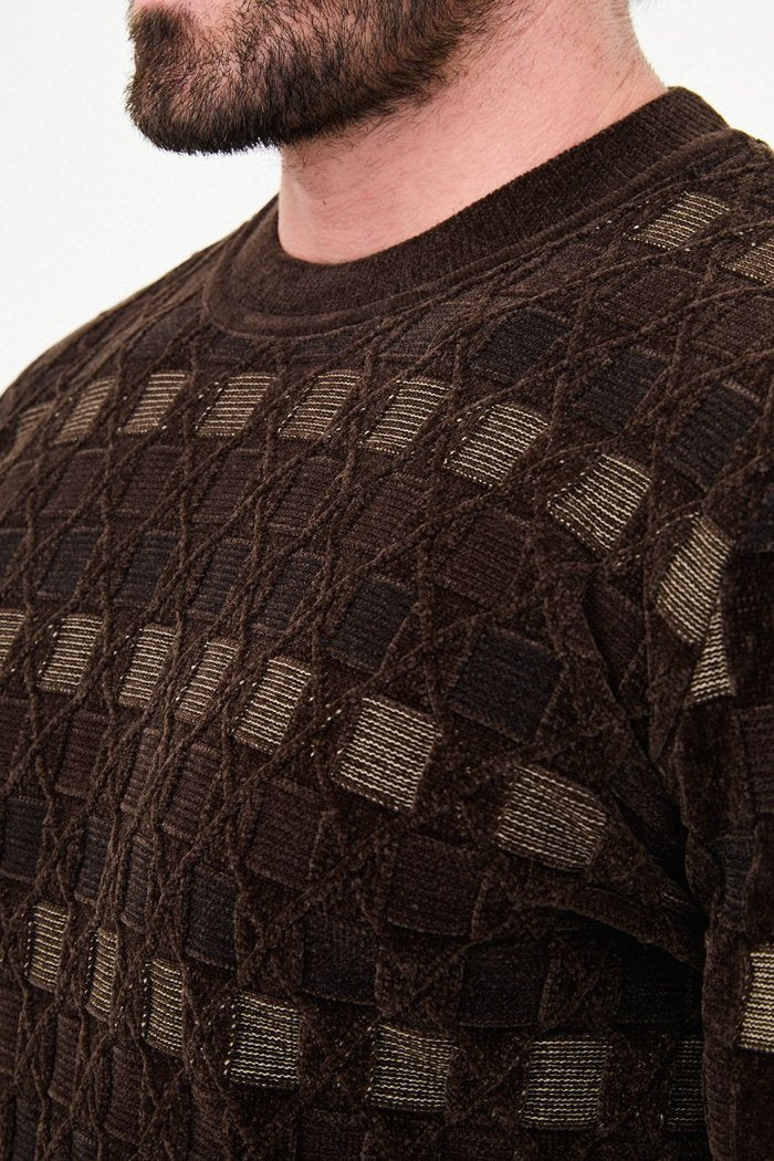 Close-up of square accents and diamond outlines in the brown sweater's knit