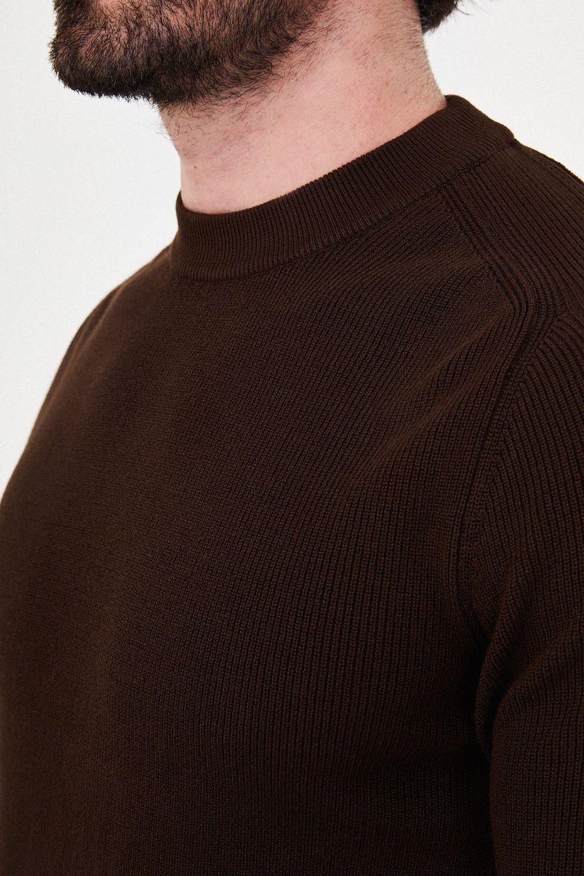 Close-up of the brown sweater's ribbed knit and raglan shoulder seam