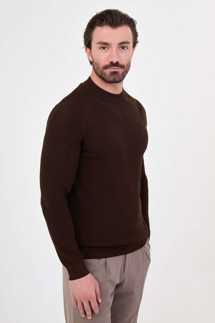 Angled view of a man wearing a brown ribbed raglan sweater