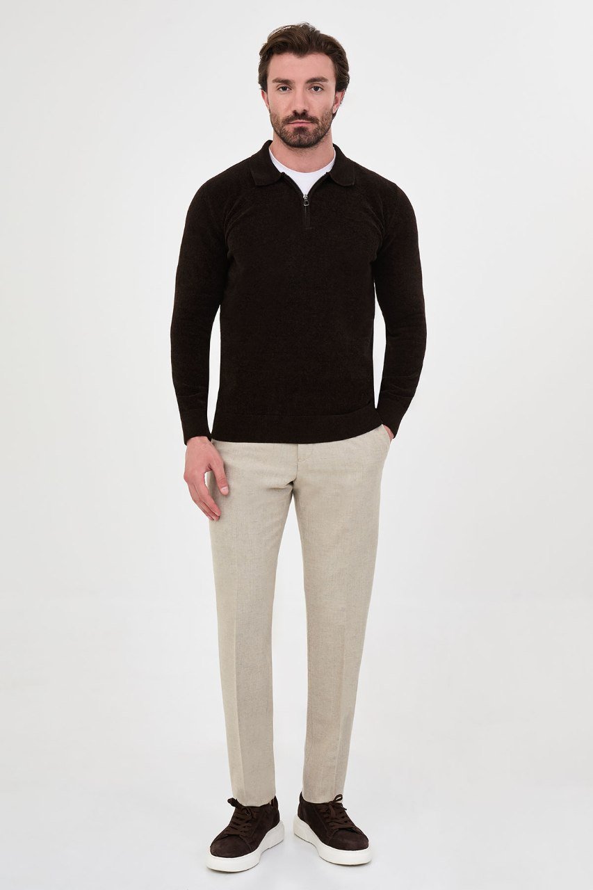 Man wearing a brown textured quarter-zip polo sweater with beige trousers