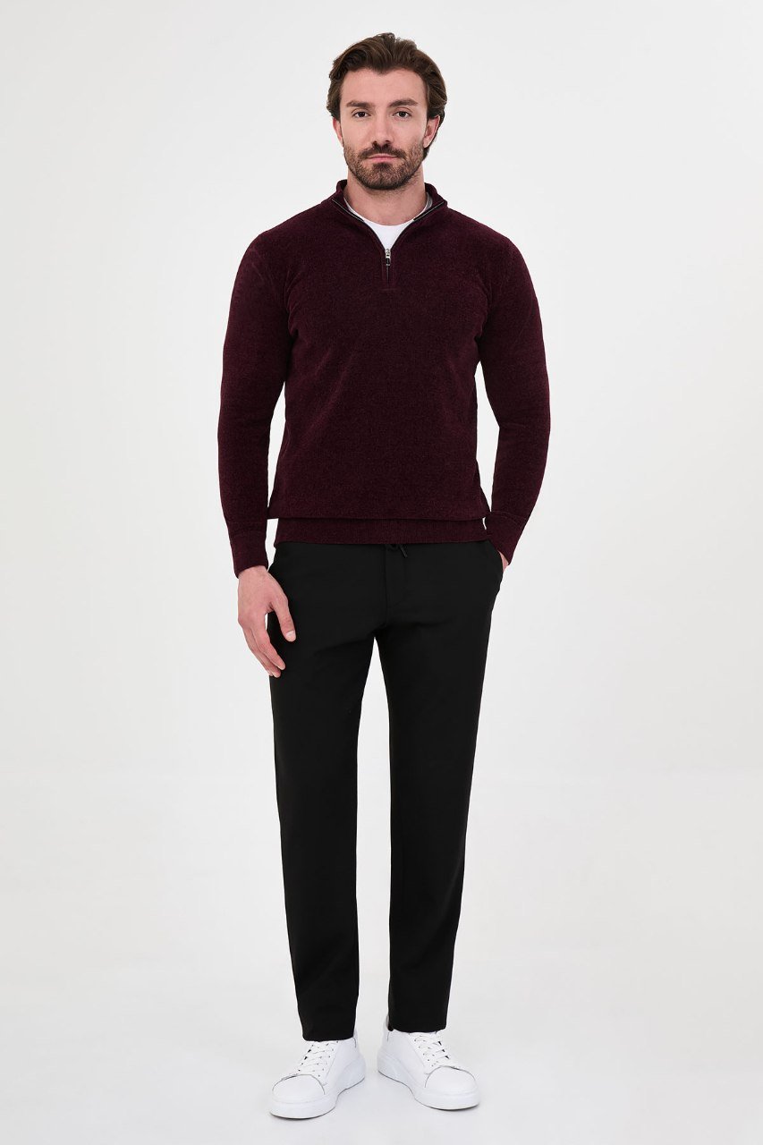 Man wearing a burgundy textured quarter-zip sweater with black trousers