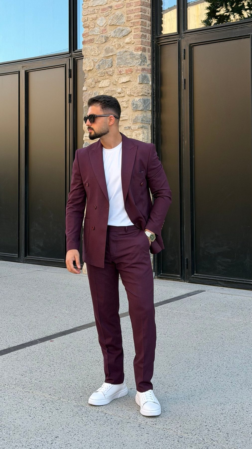 Men's burgundy two-piece suit styled with white T-shirt and sneakers