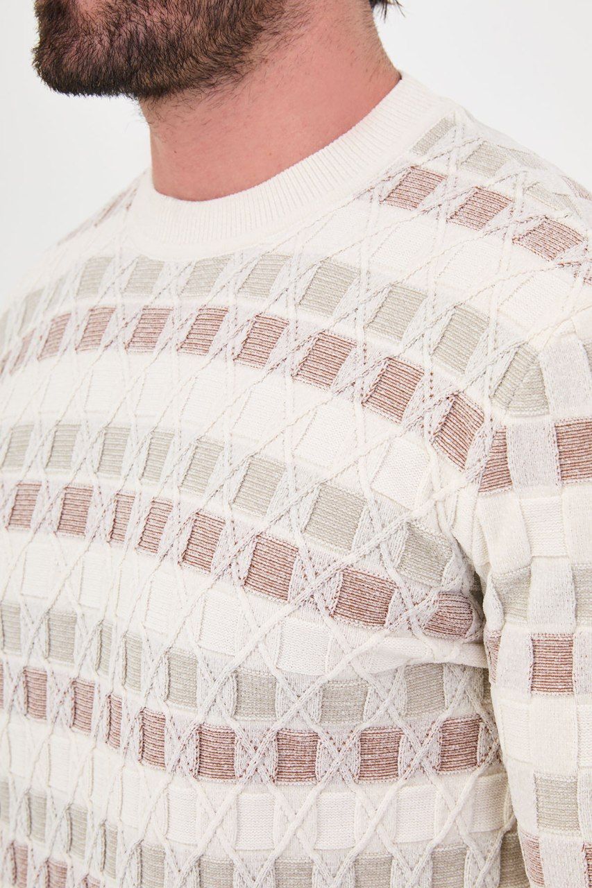 Close-up of square accents and diamond outlines in the ecru sweater's knit