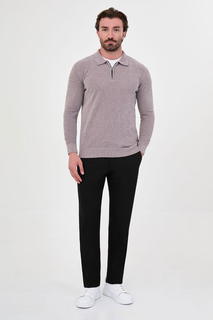 Man wearing a grey textured quarter-zip polo sweater with black trousers
