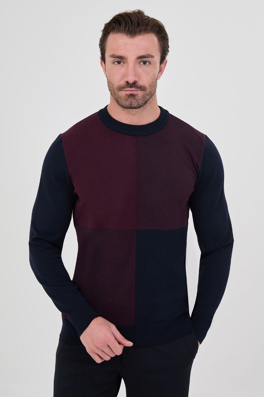 Front view of a man wearing a navy blue and burgundy colour-block crew neck sweater