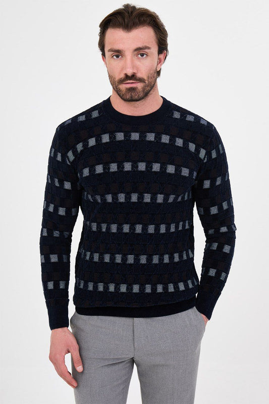 Front view of a man wearing a navy blue geometric knit crew neck sweater