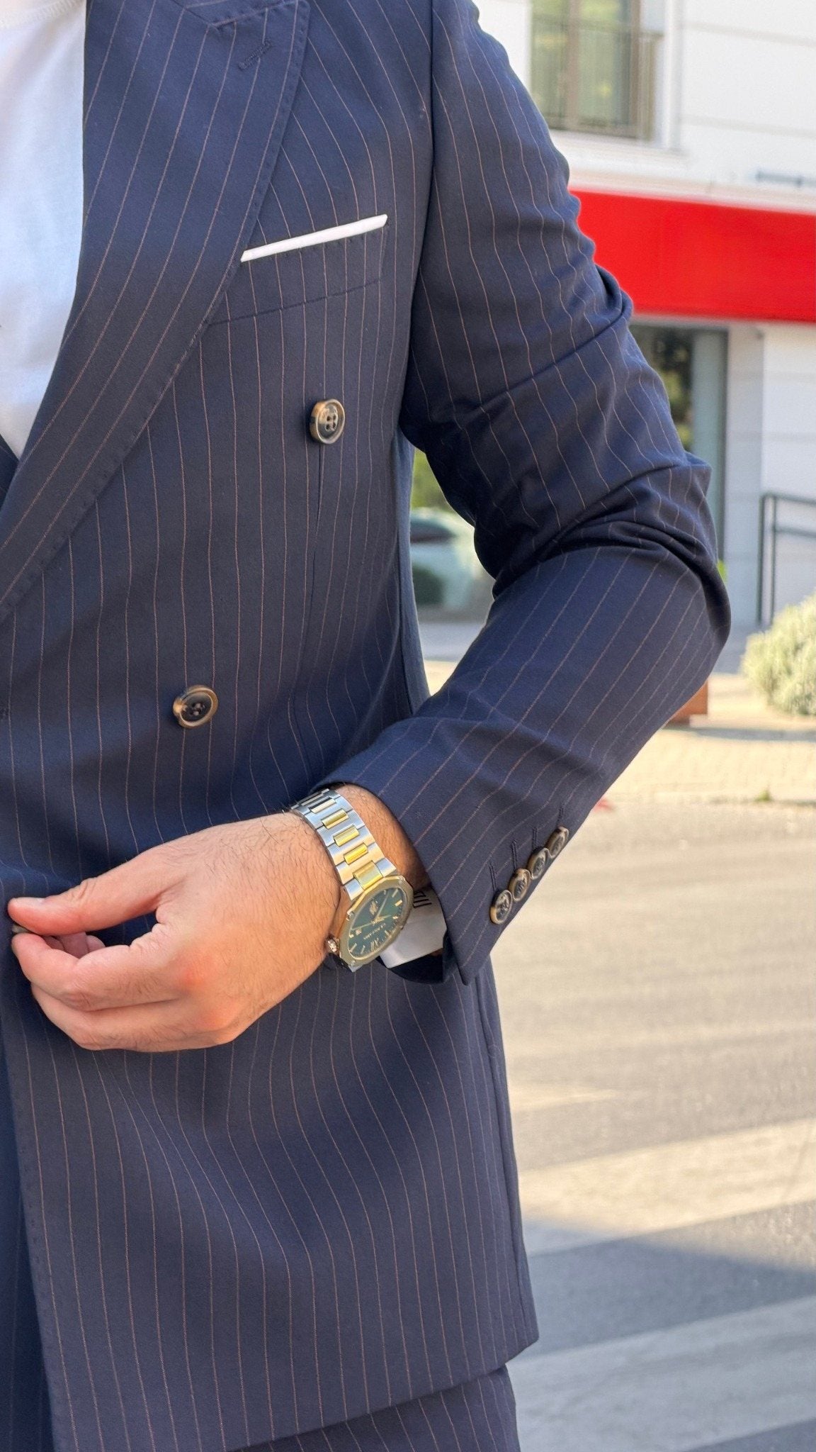 Navy blue pinstripe double-breasted suit sleeve and cuff button detail