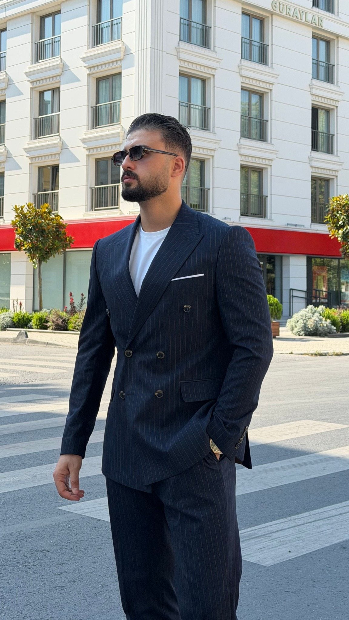 Men's navy blue pinstripe double-breasted suit styled with a white T-shirt