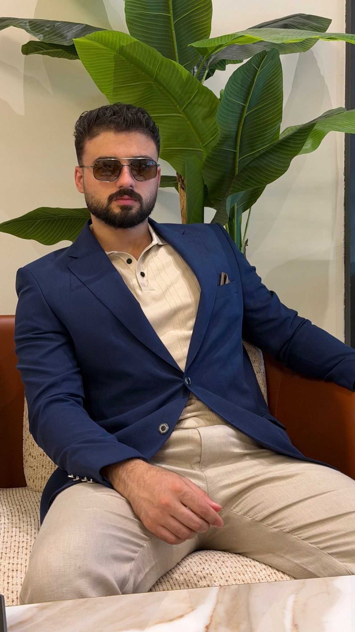 Men's navy blue single-breasted blazer with notch lapels, seated front view