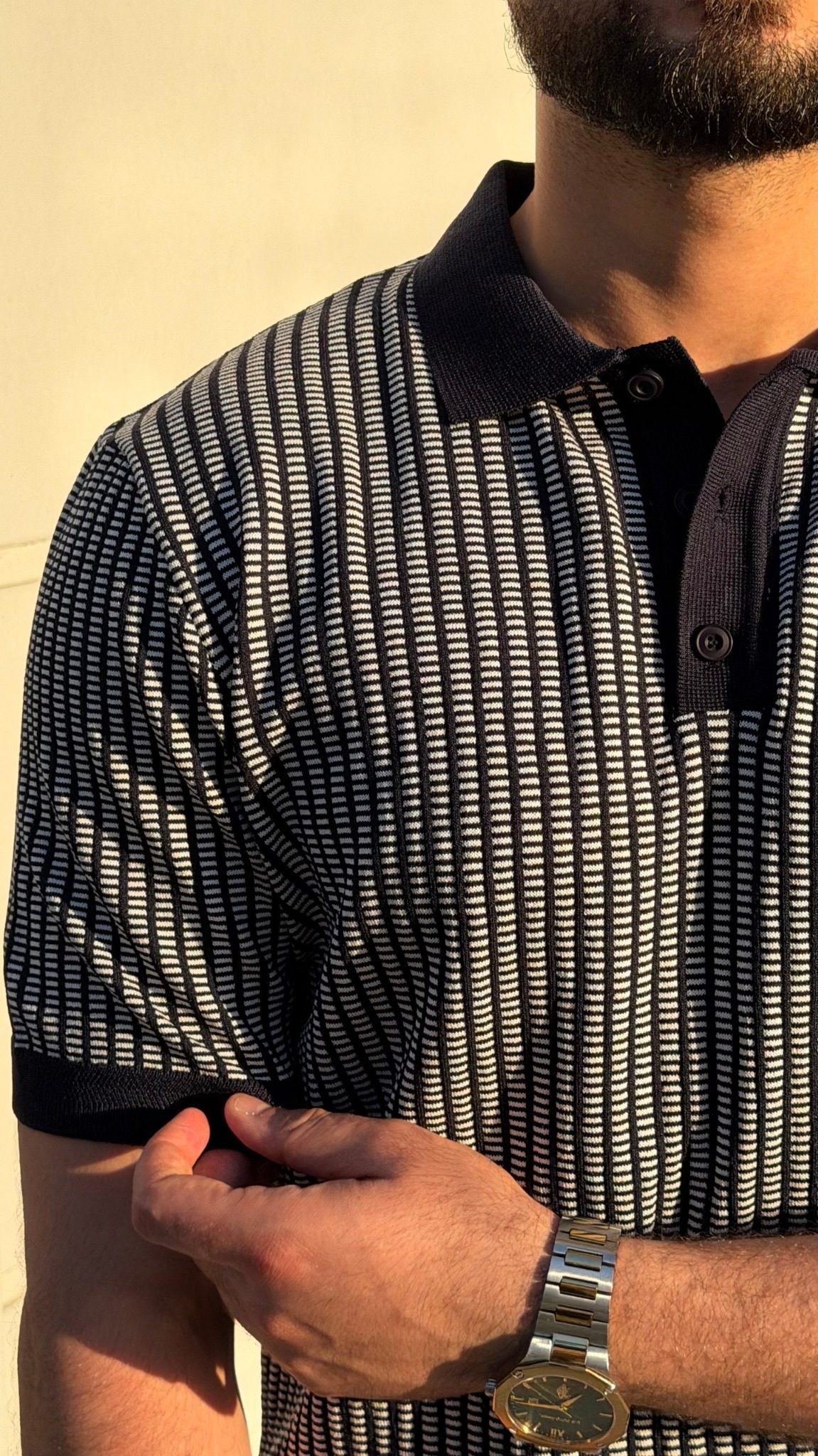 Close-up of men's navy blue textured knit polo shirt pattern and sleeve trim