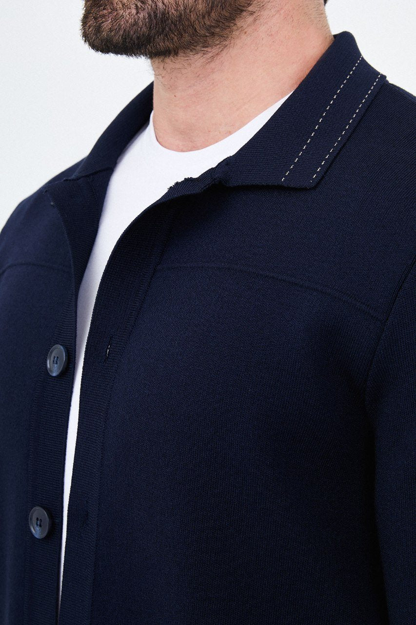 Close-up of the navy cardigan showing knit texture and contrast stitching on the collar