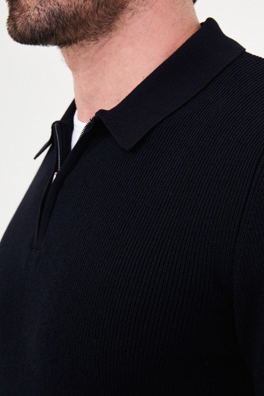Close-up of the navy sweater's ribbed knit, polo collar and metal quarter-zip fastening