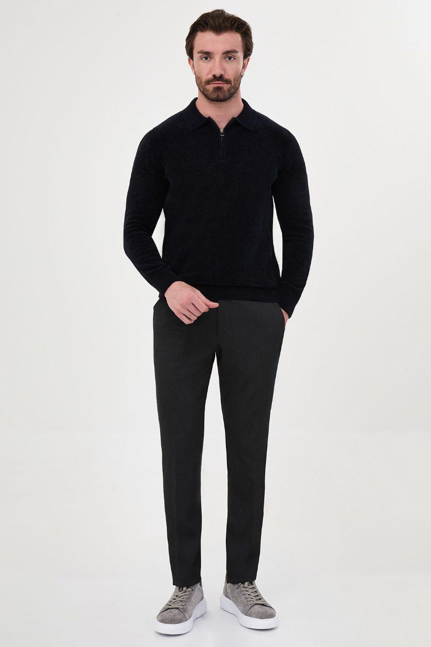 Man wearing a navy textured quarter-zip polo sweater with grey trousers
