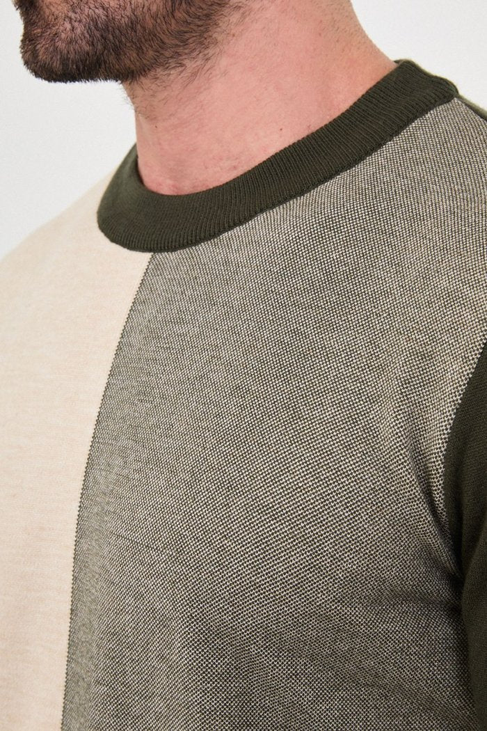 Close-up of the olive green colour-block sweater's crew neckline and contrasting knit panels