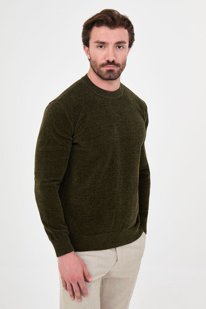 Angled view of a man wearing a olive textured crew-neck sweater
