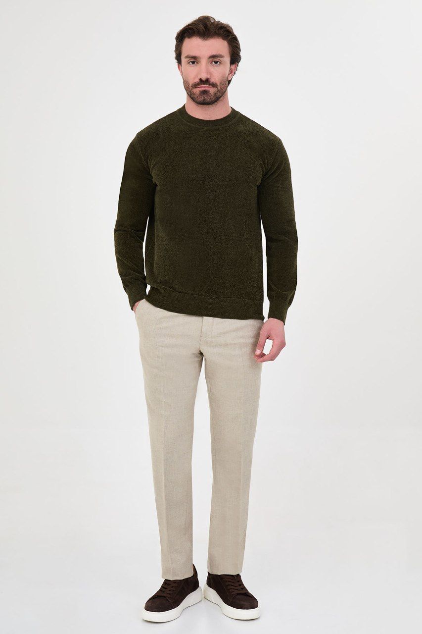 Man wearing a olive textured crew-neck sweater with beige trousers