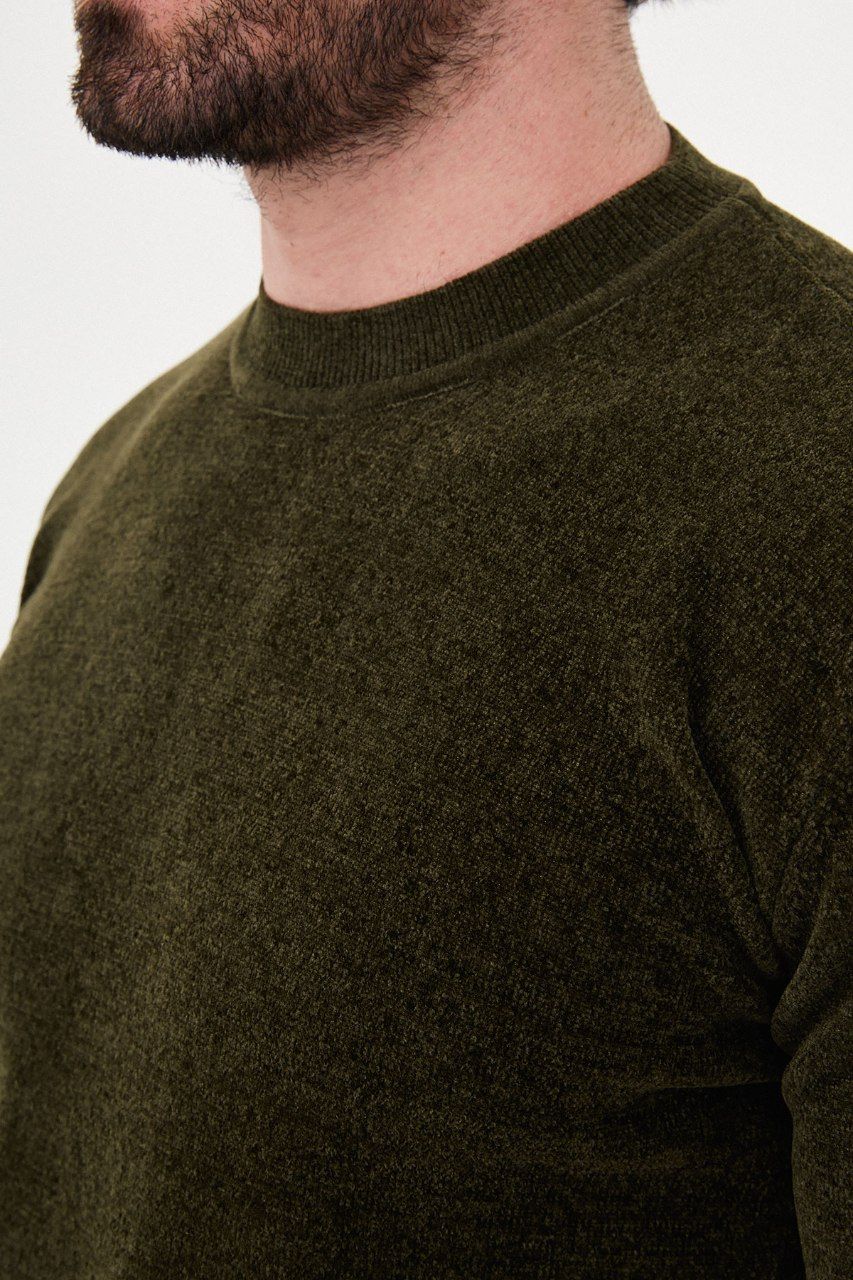 Close-up of the olive sweater's textured knit and crew neckline