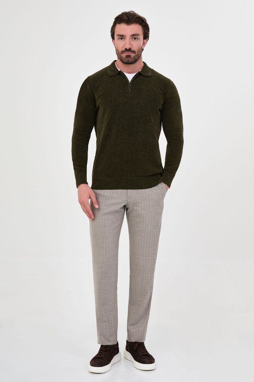 Man wearing a olive textured quarter-zip polo sweater with grey trousers