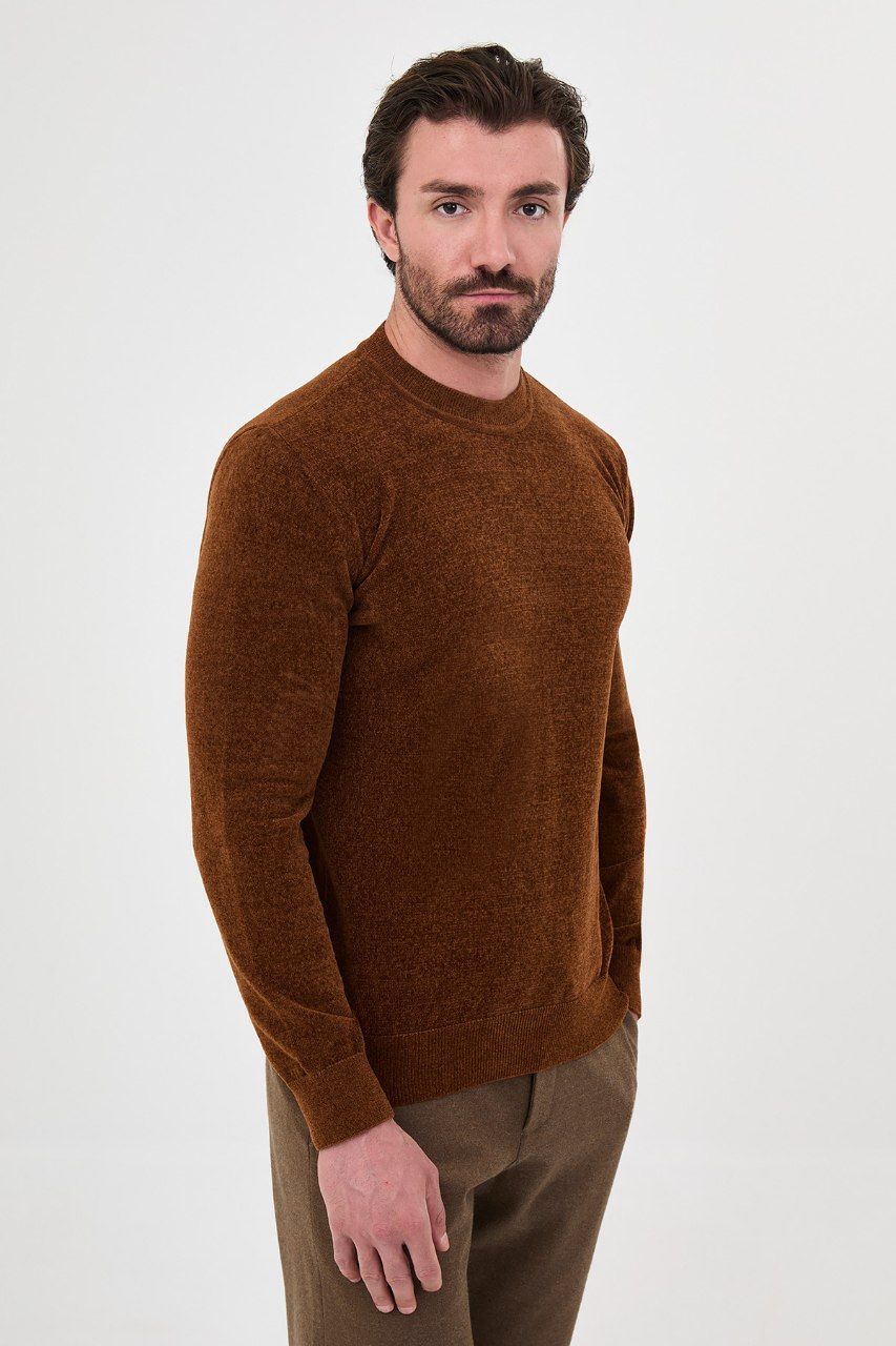 Angled view of a man wearing a rust textured crew-neck sweater