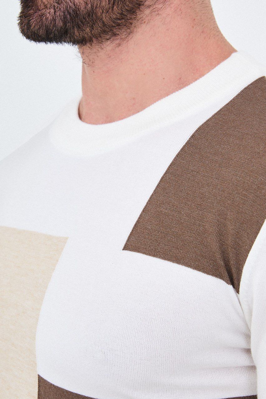 Close-up of the white sweater's crew neckline and asymmetric colour-block knit