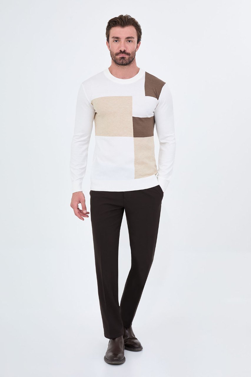 Man wearing a white colour-block sweater with black trousers