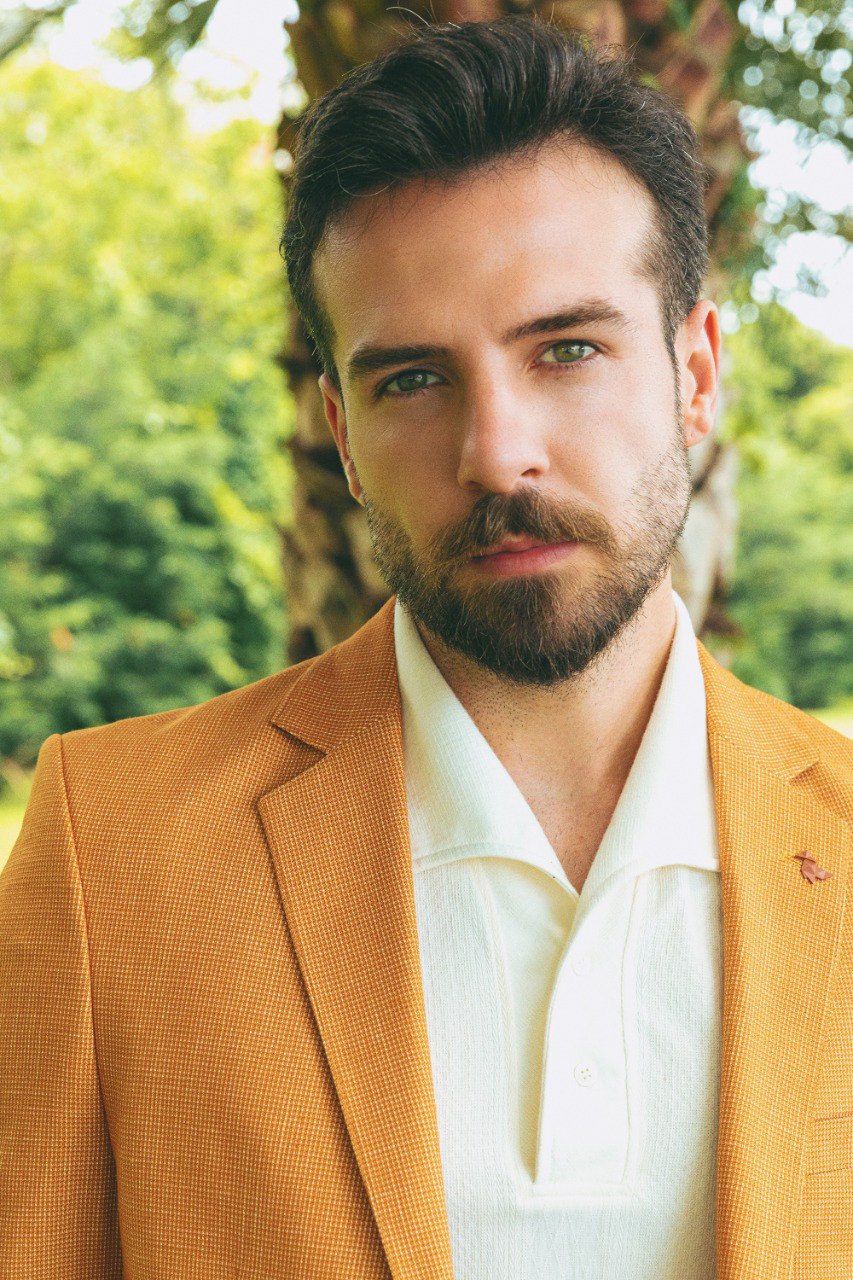 Man wearing a Golden Hour Blazer with a pointed collar, flap pockets, and a slim fit, perfect for summer weddings and casual outings.