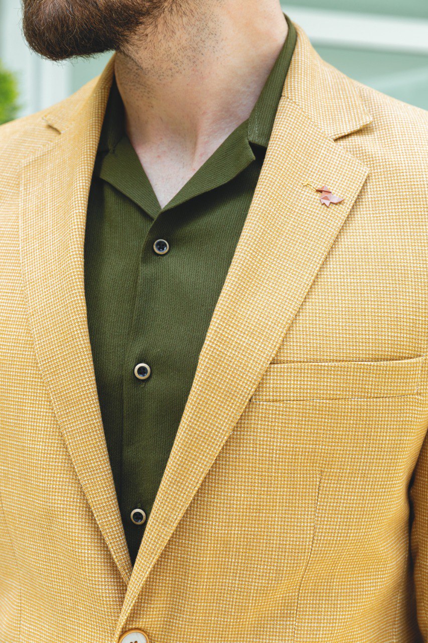 Man wearing a Sunlit Meadow Blazer with a pointed collar, flap pockets, and a slim fit, perfect for summer weddings and casual outings.