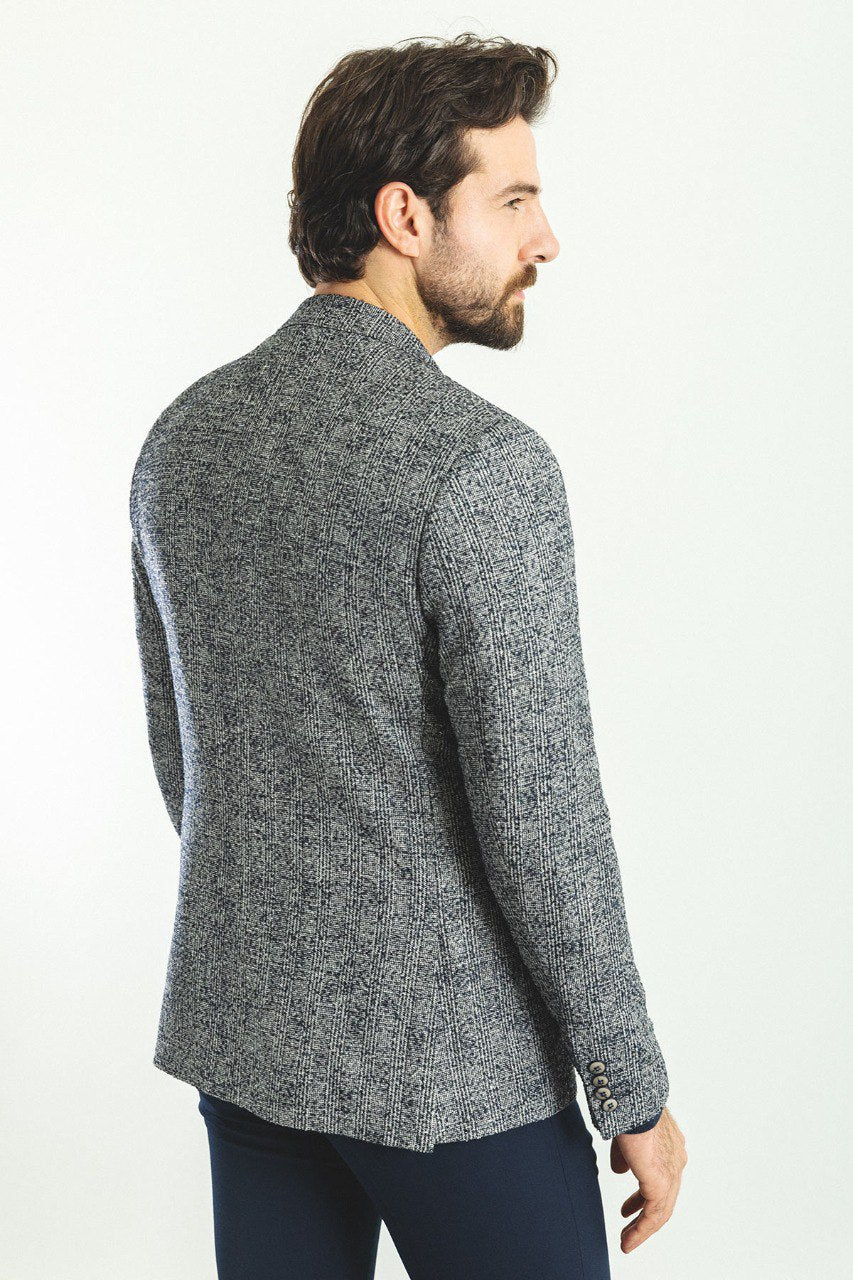 Man wearing a Charcoal Tweed Blazer with a pointed collar, flap pockets, and a slim fit, perfect for business meetings and formal gatherings.