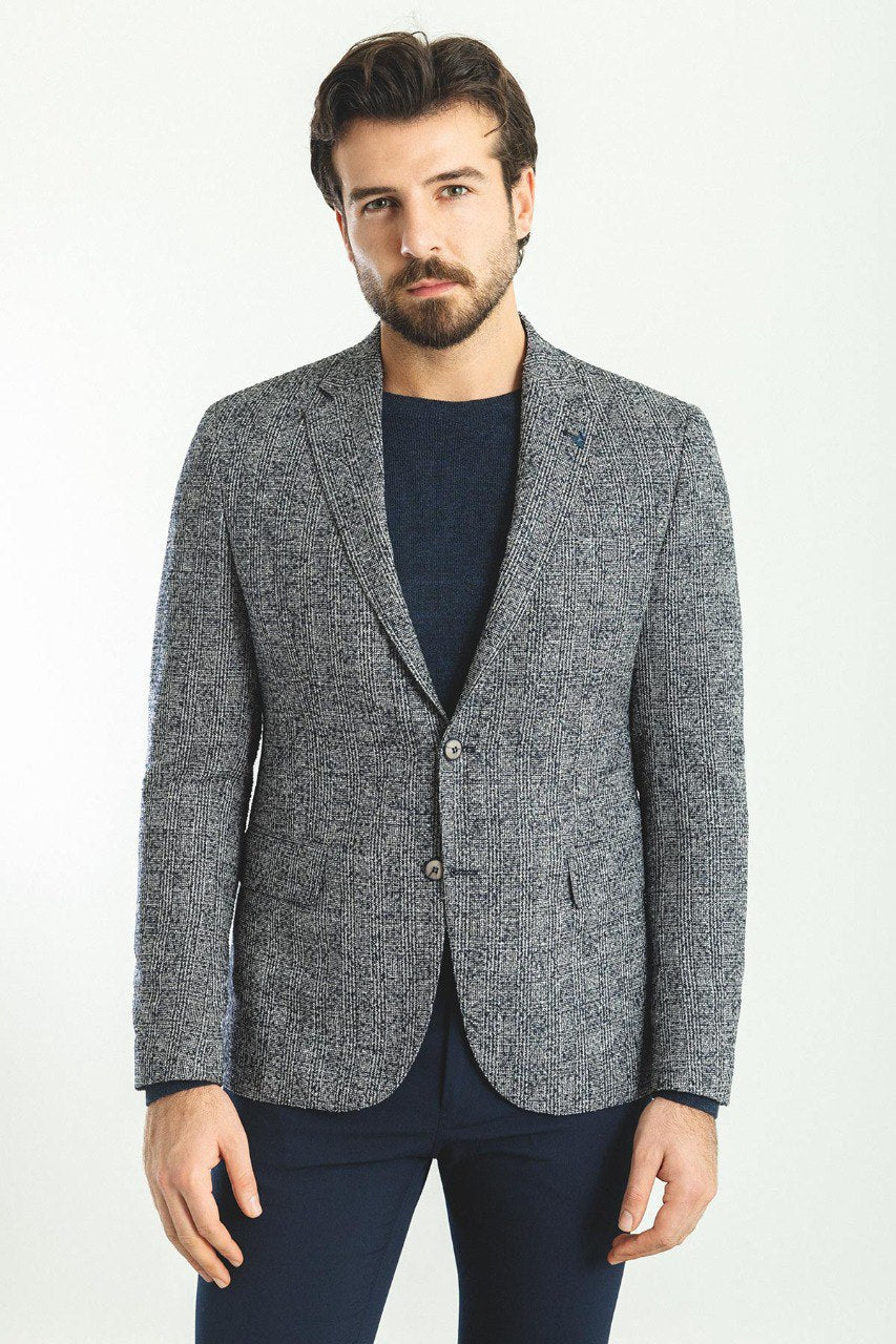 Man wearing a Charcoal Tweed Blazer with a pointed collar, flap pockets, and a slim fit, perfect for business meetings and formal gatherings.