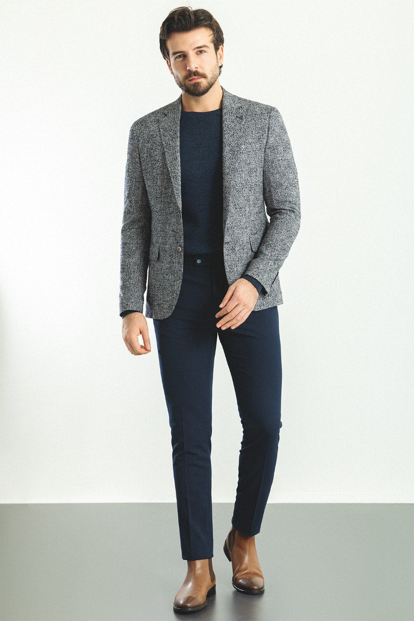 Man wearing a Charcoal Tweed Blazer with a pointed collar, flap pockets, and a slim fit, perfect for business meetings and formal gatherings.