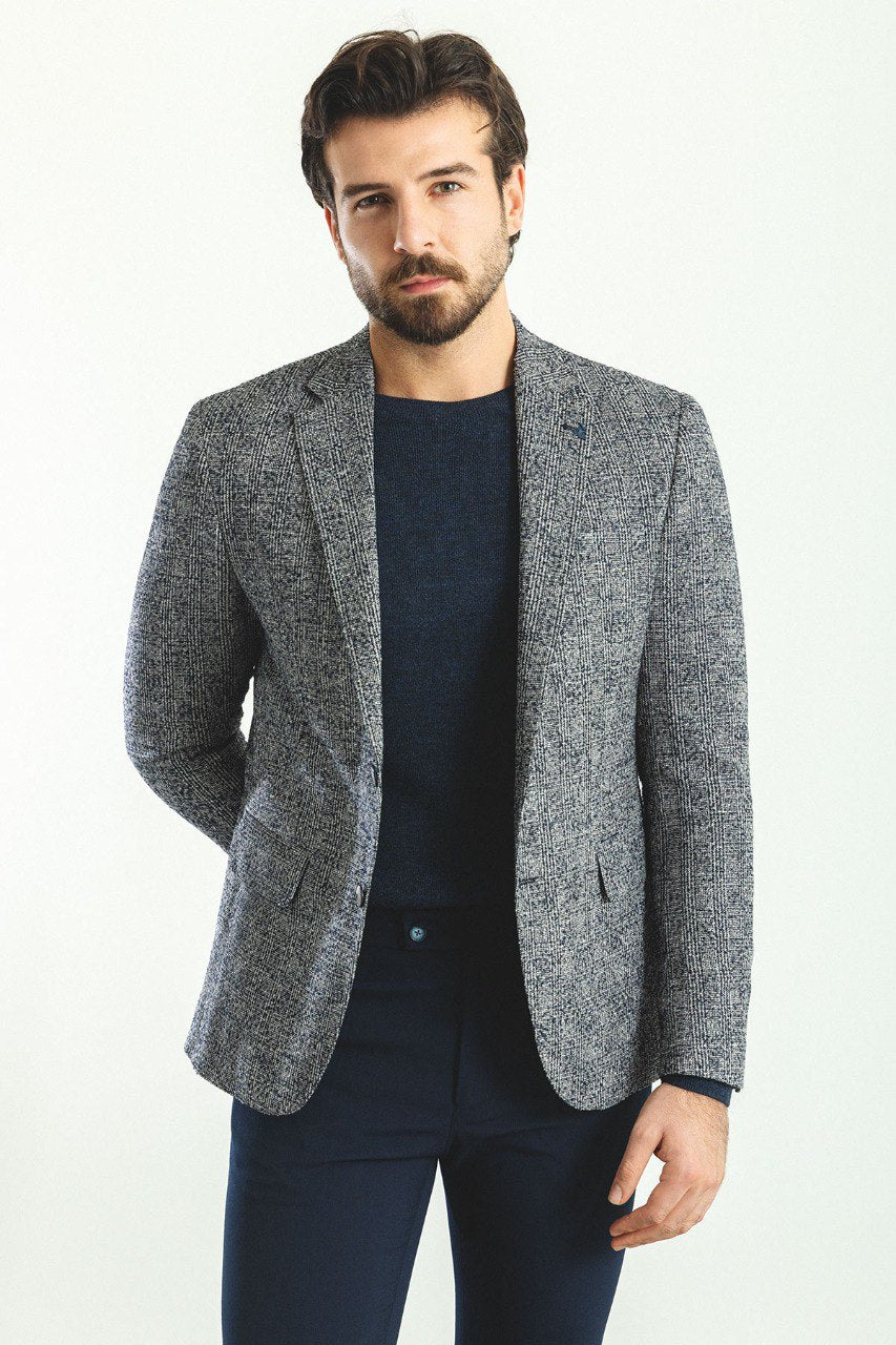 Man wearing a Charcoal Tweed Blazer with a pointed collar, flap pockets, and a slim fit, perfect for business meetings and formal gatherings.