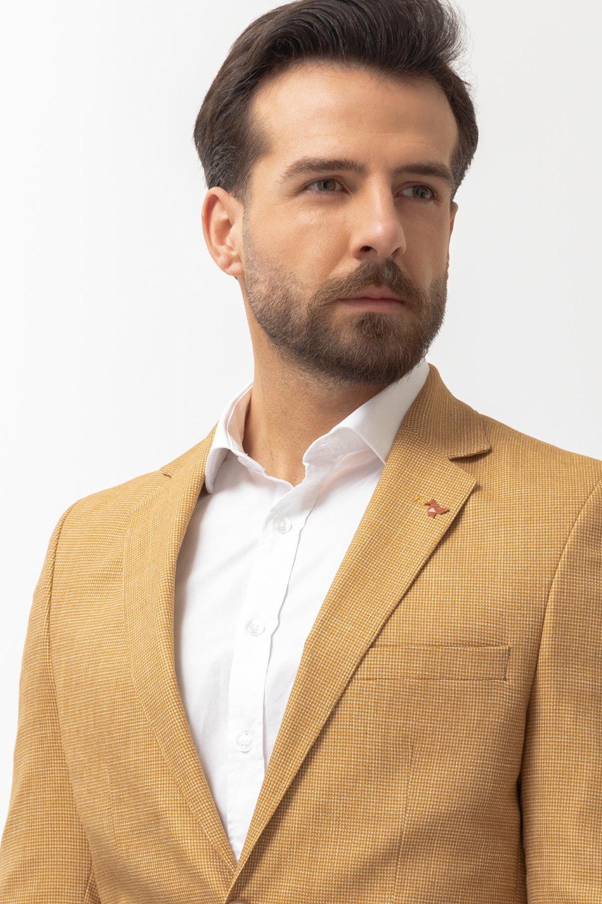 Man wearing a Sunlit Meadow Blazer with a pointed collar, flap pockets, and a slim fit, perfect for summer weddings and casual outings.