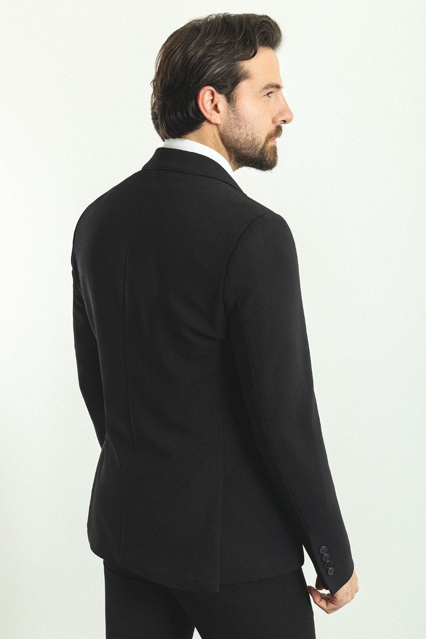 Man wearing a Noir Majesty Blazer with a pointed collar, flap pockets, and a double-button closure, perfect for weddings and formal events.