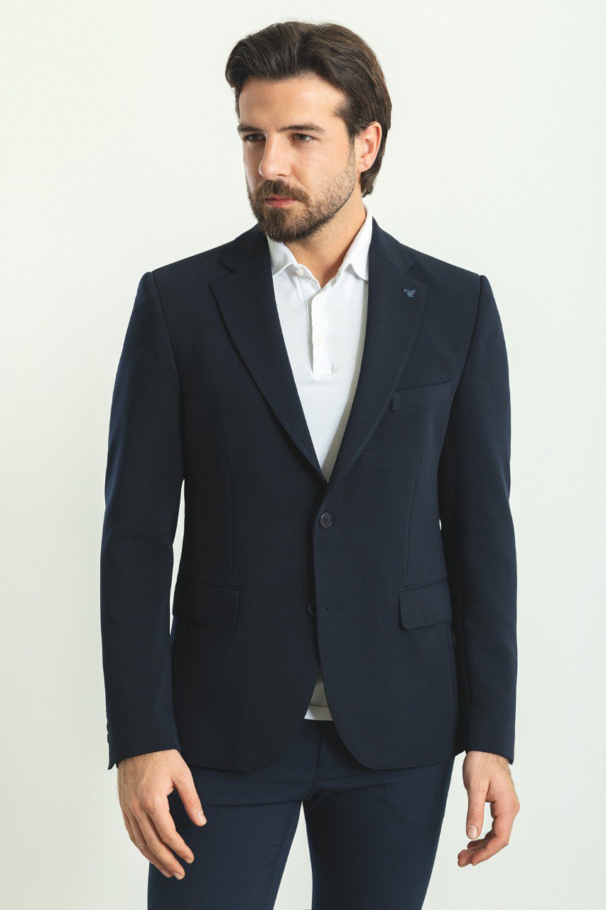 Man wearing a Nautical Nightfall Blazer with a sharp pointed collar, flap pockets, and a double-button closure, perfect for weddings and formal occasions.