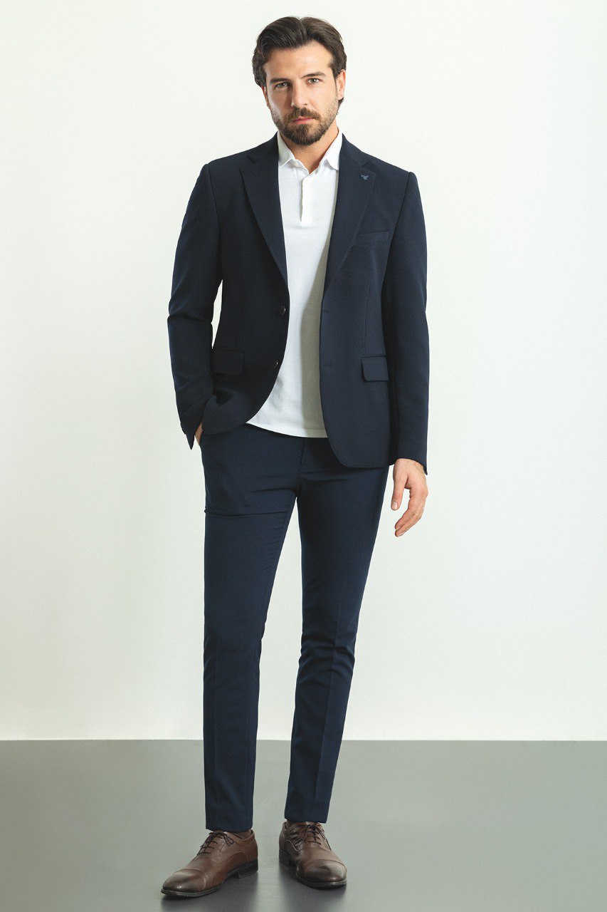 Man wearing a Nautical Nightfall Blazer with a sharp pointed collar, flap pockets, and a double-button closure, perfect for weddings and formal occasions.