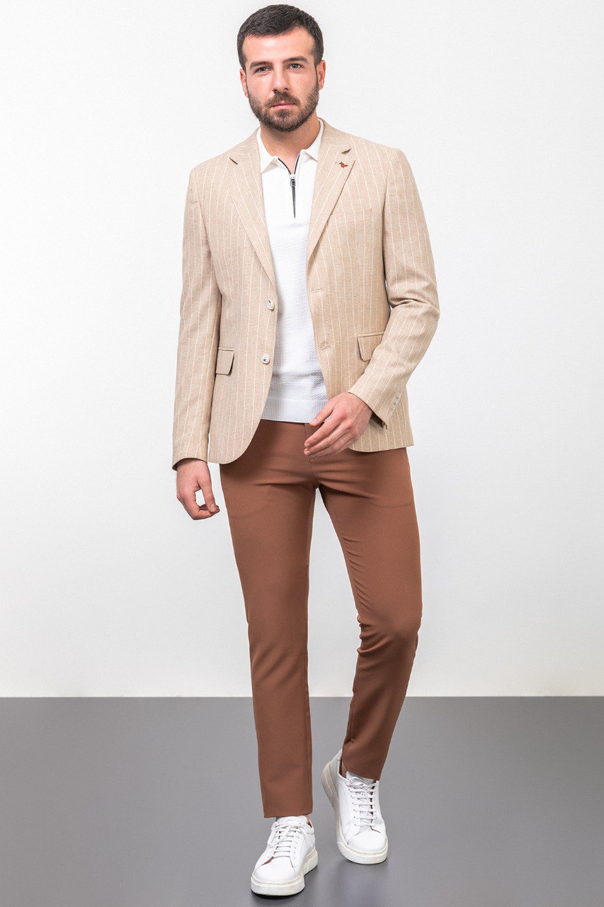 Man wearing a beige pinstripe blazer paired with brown trousers.