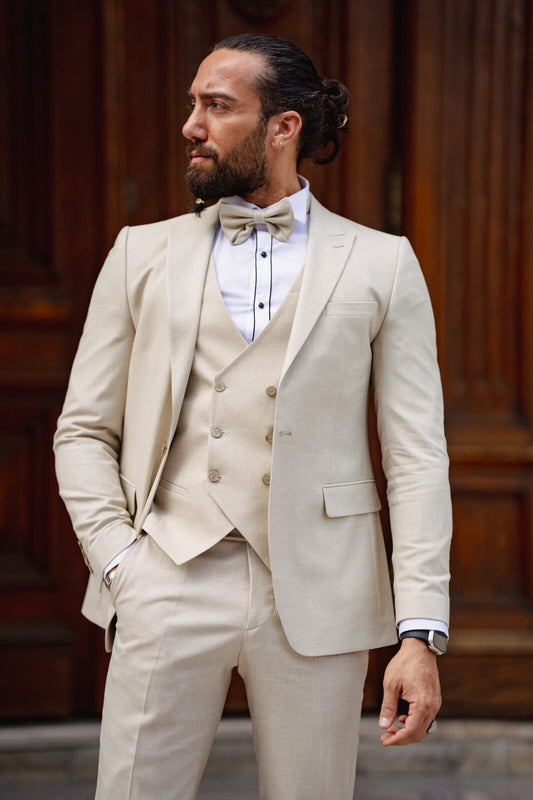 A man modeling a Birch Beige Tuxedo Suit with a bow tie